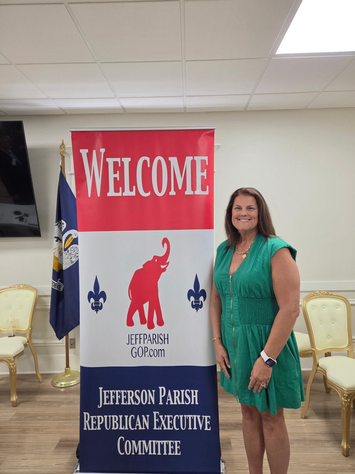 Linda Domangue beside the Jefferson Parish Republican Executive Committee banner